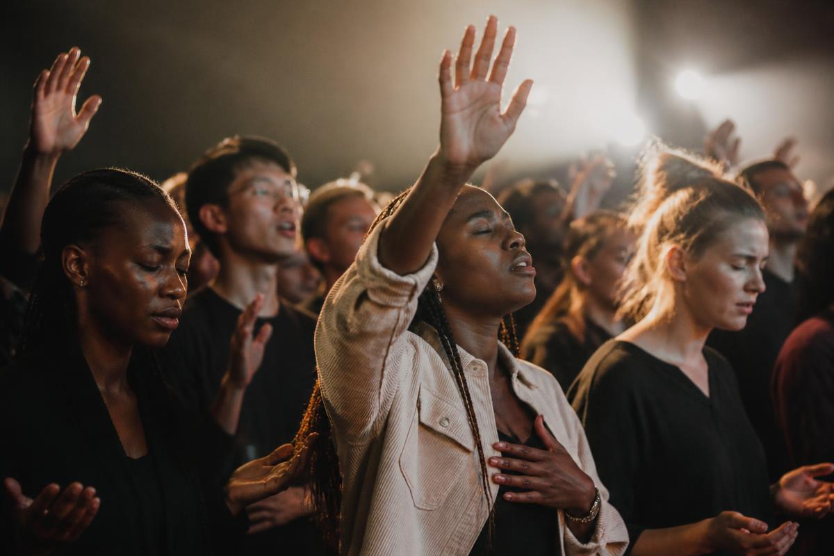 Young adults worshipping with hands raised